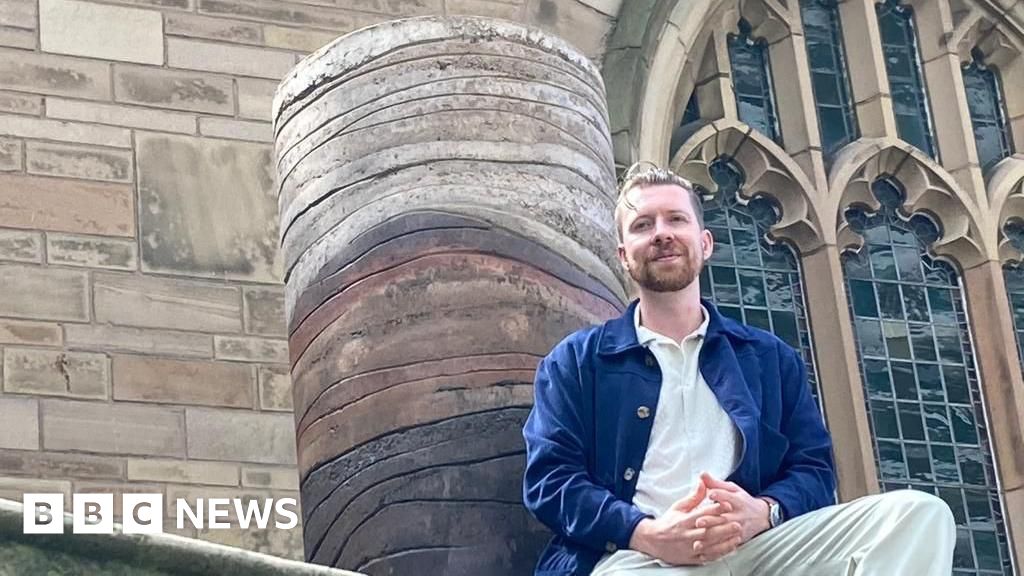 Benjamin Stephenson and Jacob Elward won the 2023 Liverpool Sculpture Prize with ‘Laminae,’ a cylindrical sculpture crafted from rammed earth inspired by red rocks on the Wirral coast, reflecting humanity’s connection to nature.