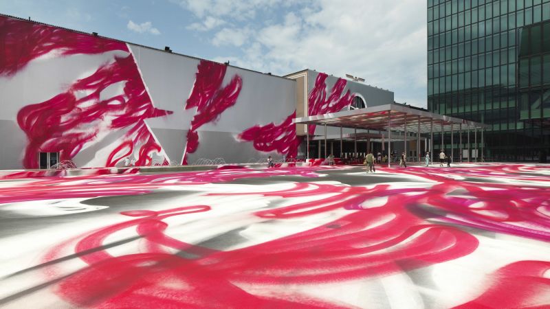 Katharina Grosse transformed a public square in Switzerland with a massive spray painting for Art Basel 2025, creating a vibrant yet temporary work titled ‘CHOIR’ that will be washed away after a week.