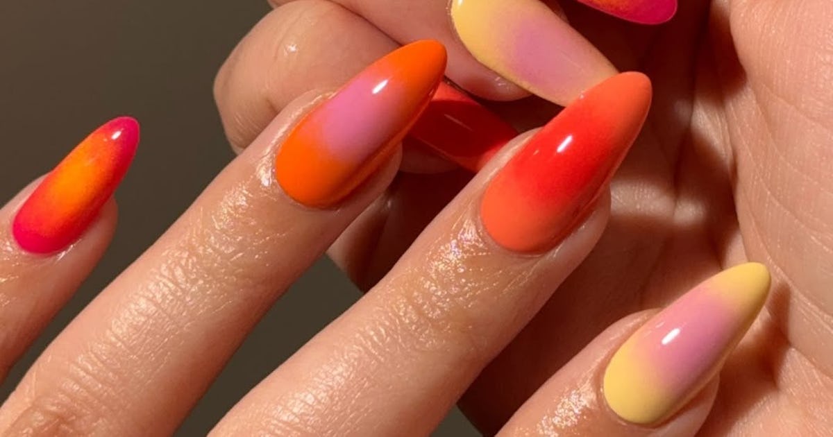 The ‘Sunset Nail’ trend features bold gradients and vibrant colors like soft golds, warm oranges, and rich reds.