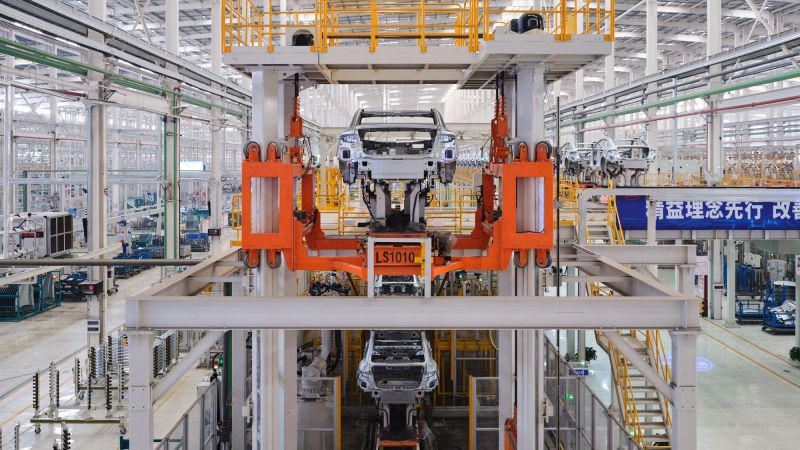 Edward Burtynsky’s photos reveal the striking contrast between advanced technology and human labor at China’s electric car factories, showcasing a place where innovation meets the heart of human resilience.