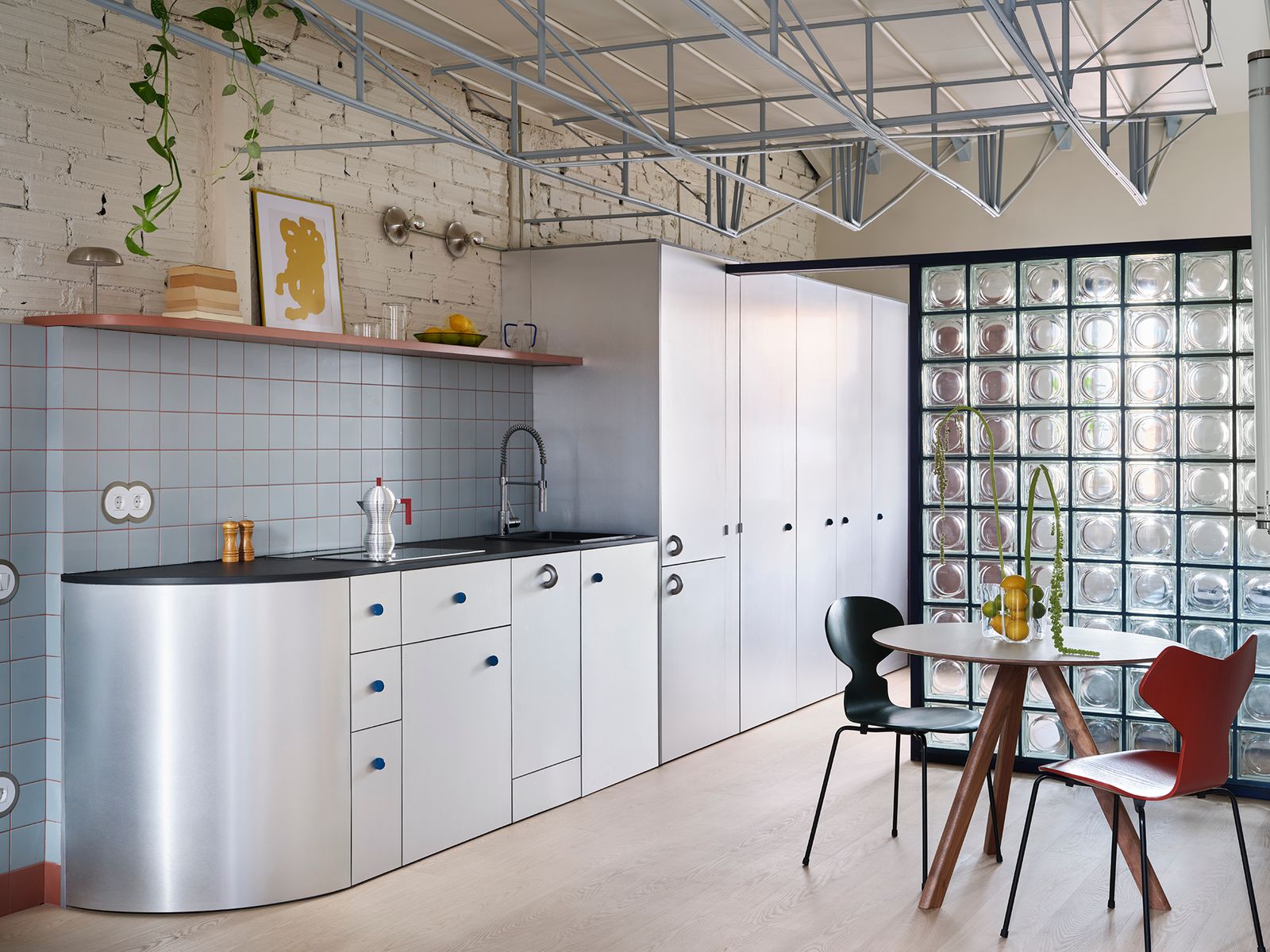The Loft in Madrid features a metal truss ceiling transformed into a functional second floor, blending structural integrity with an open, stylish design and color scheme for visual depth.